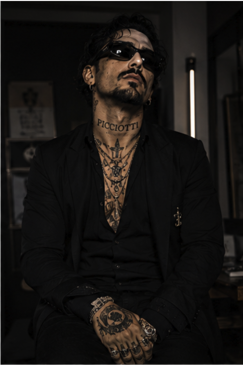 Portrait of Giovanni Picciotti in black tailoring with layered chains